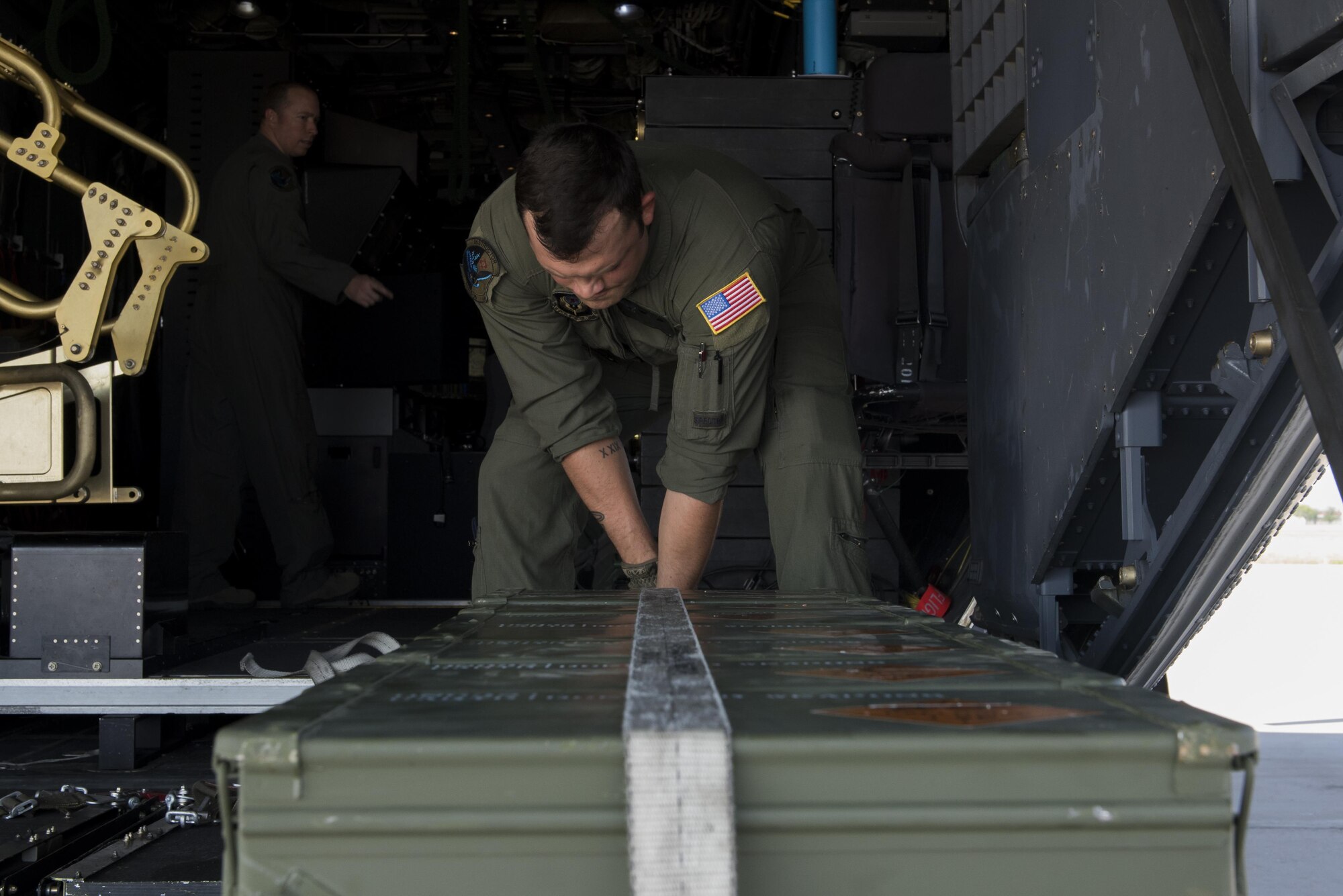 Senior Airman Justin Bird, 551st Special Operations Squadron aerial gunner, straps down 30mm ammunition containers aboard an AC-130W Stinger II at Cannon Air Force Base, New Mexico, June 13, 2017. The objective for the mission was live-fire training as well as an opportunity to train students. (U.S. Air Force photo by Staff Sgt. Michael Washburn/Released)