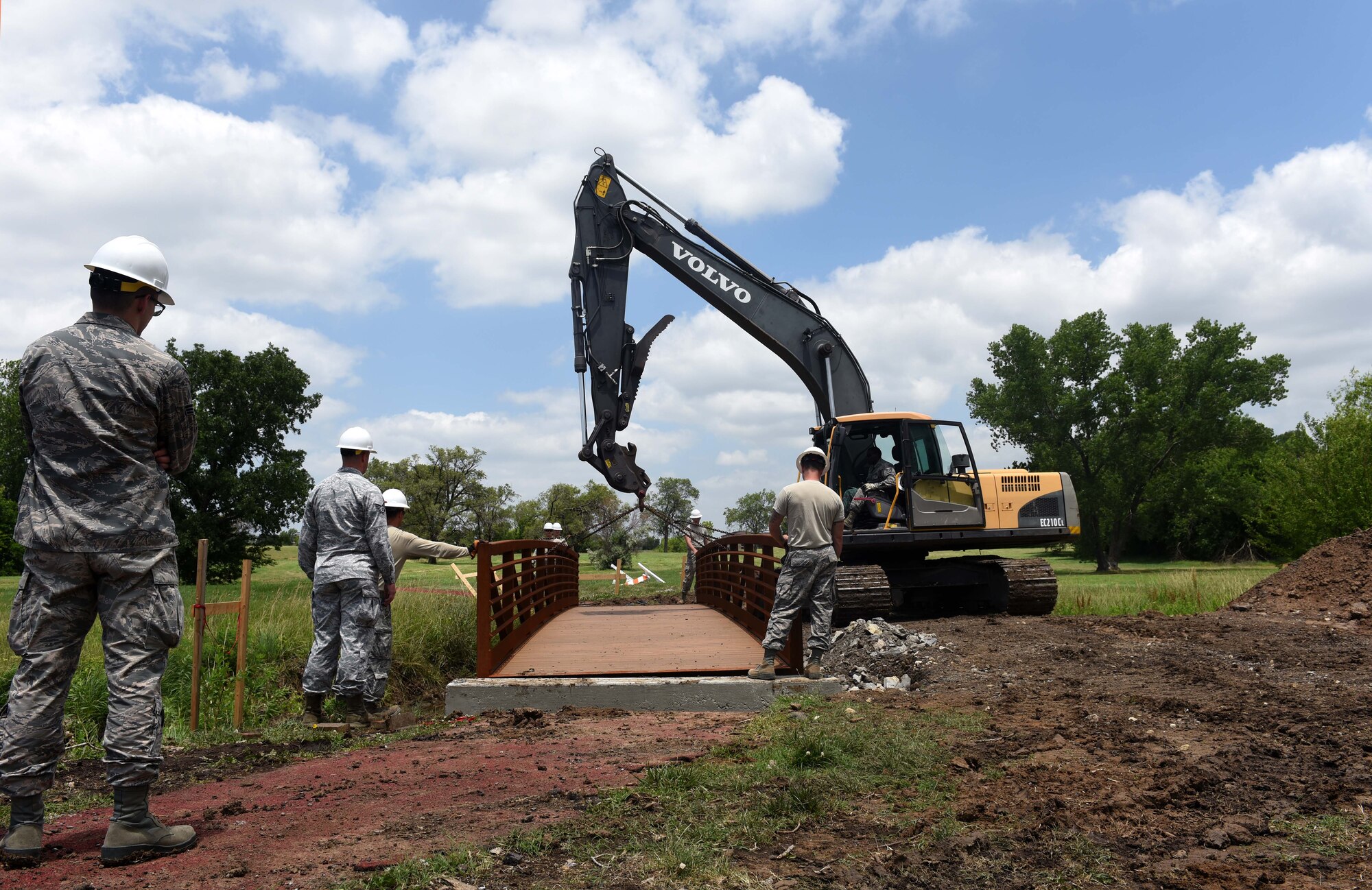 Twenty-second Civil Engineer Squadron Airmen replace a bridge June 14, 2017 at the Kruger Recreational 2-mile track at McConnell Air Force Base, Kan. The Airmen used a crane to align a new bridge on the track to increase safety for runners. (U.S. Air Force photo/Airman 1st Class Alan Ricker)