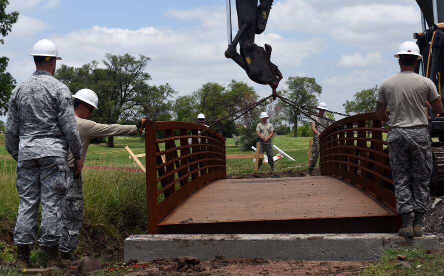Twenty-second Civil Engineer Squadron Airmen move a bridge June 14, 2017 at the Kruger Recreational 2-mile track at McConnell Air Force Base, Kan. The 22nd CES set the new bridge in the correct position on the track. (U.S. Air Force photo/Airman 1st Class Alan Ricker)