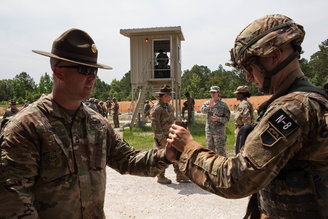 Sgt. 1st Class Justin Donze, a drill sergeant with E Company, 1st Battalion, 330th Infantry Regiment, 3rd Brigade, 95th Training Division, hands ammunition to Sgt. Alexander Dennis, Headquarter and Headquarters Command, 472nd Chemical Battalion, at the 2017 U.S. Army Reserve Best Warrior Competition at Fort Bragg, N.C., June 13. This year's Best Warrior Competition will determine the top noncommissioned officer and junior enlisted Soldier who will represent the U.S. Army Reserve in the Department of the Army Best Warrior Competition later this year at Fort A.P. Hill, Va. (U.S. Army Reserve photo by Lisa Velazco) (Released)