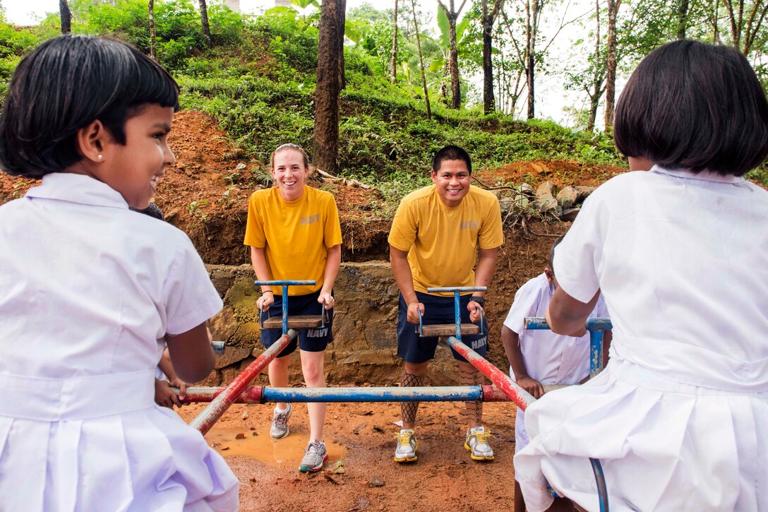 Navy Lt. Mark Rittenhouse, right, and Navy Ensign Natalie Miller play on a teeter totter with students at the Kalutara-Molkawa School near Kalutara, Sri Lanka, June 15, 2017, during a community engagement. Navy photo by Petty Officer 2nd Class Joshua Fulton
