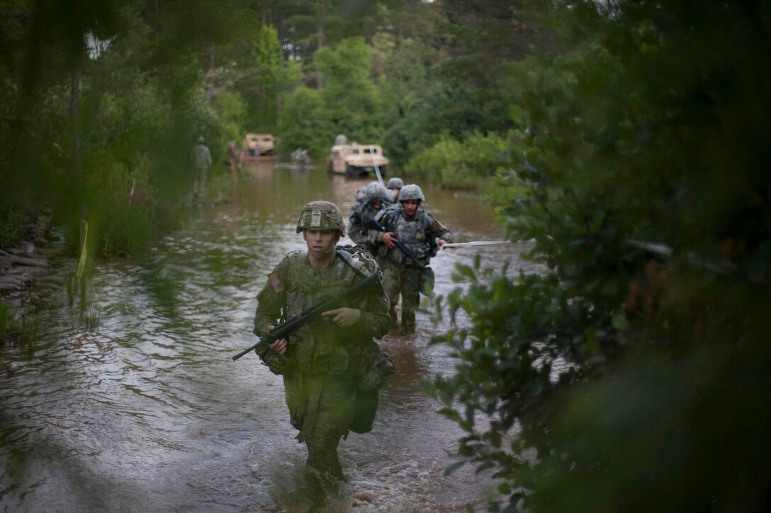 Warriors wade thier way through water as he competes in Foot March, at the 2017 U.S. Army Reserve Best Warrior Competition at Fort Bragg, N.C., June 13. This year's Best Warrior Competition will determine the top noncommissioned officer and junior enlisted Soldier who will represent the U.S. Army Reserve in the Department of the Army Best Warrior Competition later this year at Fort A.P. Hill, Va. (U.S. Army Reserve photo by Spc. Jesse L. Artis Jr.) (Released)