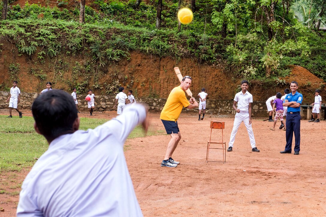 Navy Capt. Darren McPherson, commander, of the guided-missile cruiser USS Lake Erie, plays cricket with students at the Kalutara-Molkawa School near Kalutara, Sri Lanka, June 15, 2017. Navy photo by Petty Officer 2nd Class Joshua Fulton 