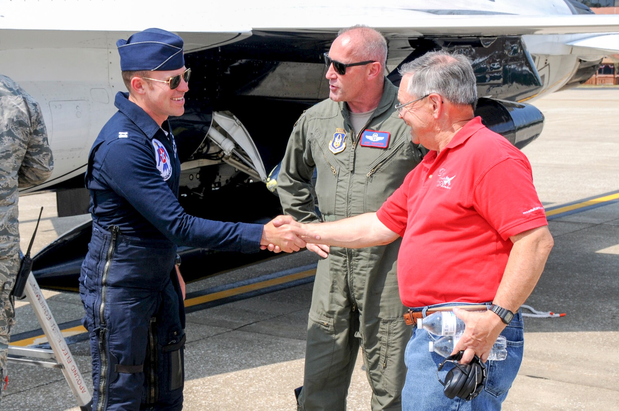 Thunderbird 8 Capt. Erik Gonsalves, the advance pilot and narrator for the U.S. Air Force Thunderbirds, greets Warren Schultz from David Schultz Airshows, LLC, and Lt. Col. Jeff Shaffer, Thunder Over the Valley Air Show director, June 14, 2017, after arriving at YARS. Gonsalves performed an aerial survey of YARS and the surrounding area before landing. The U.S. Air Force Thunderbirds demonstration team is scheduled to perform at Thunder Over the Valley Air Show, June 17-18. (U.S. Air Force photo/Senior Airman Joshua Kincaid)