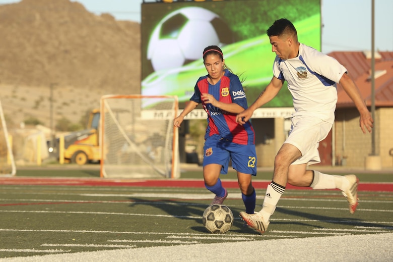 Miguel Torres, midfielder, Headquarters Battalion team, fights for possession of the ball against a marine from 1st Tank Battalion team during the intramural soccer championship game at Felix Field aboard the Marine Corps Air Ground Combat Center, Twentynine Palms, Calif., June 12, 2017. Marine Corps Community Services, Semper Fit, hosts an intramural soccer league for units aboard the installation. Tanks came out victorious with a score of 2-1. (U.S. Marine Corps photo by Lance Cpl. Christian Lopez)