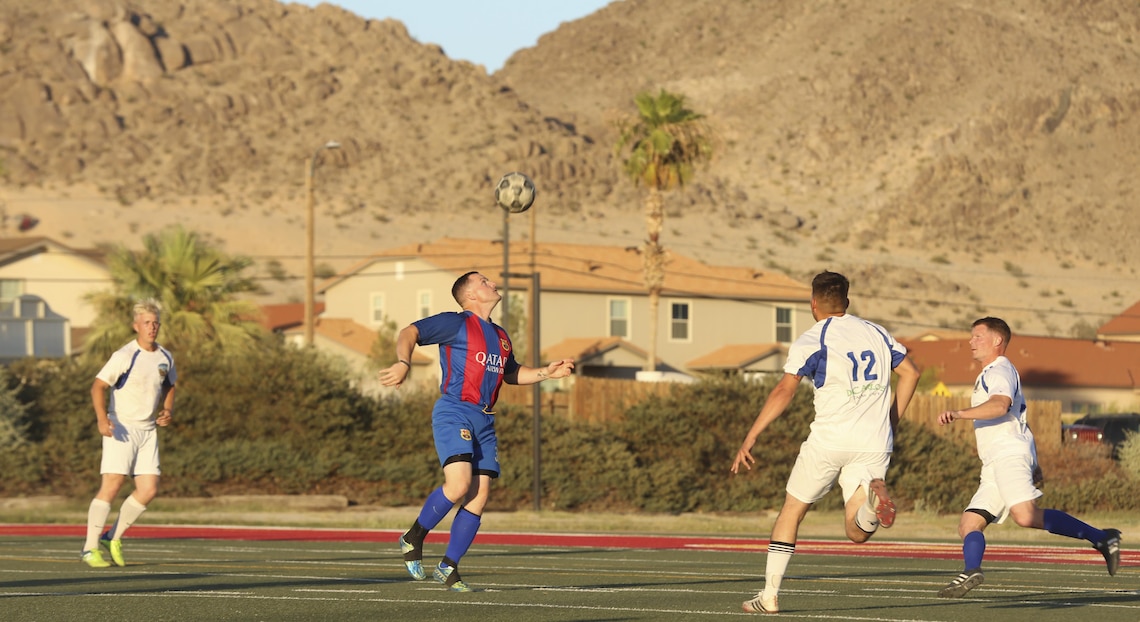Headquarters Battalion's defense tries to recover possession of the ball from 1st Tank Battalion during the intramural soccer championship game at Felix Field aboard the Marine Corps Air Ground Combat Center, Twentynine Palms, Calif., June 12, 2017. Marine Corps Community Services, Semper Fit, hosts an intramural soccer league for units aboard the installation. Tanks came out victorious with a score of 2-1. (U.S. Marine Corps photo by Lance Cpl. Christian Lopez)