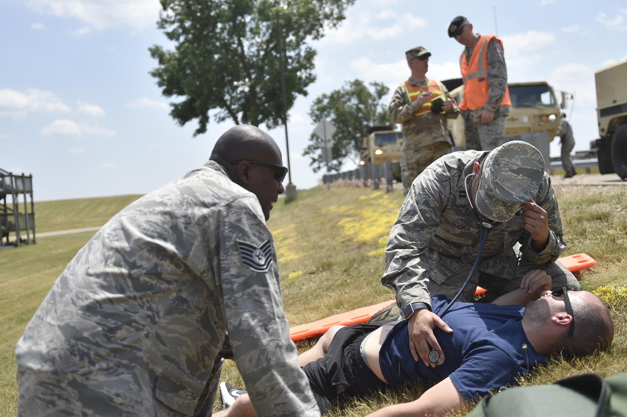 Tech. Sgt. Carliteau Leger, 60th Aerospace Medicine Squadron bioenvironmental engineer and Capt. (Dr.) Ricardo Sequeira, 14th Airlift Squadron flight surgeon provide first aid to a simulated victim during Exercise Turbo Distribution 17-02, June 9, 2017, at Battle Creek Air National Guard Base, Mich.  Turbo Distribution is used to evaluate mobility operations and expeditionary combat support. Unlike traditional, simulation based exercises, TD provides a dynamic venue with scenarios designed to challenge participants executing complex operations in a deployed environment.  (U.S. Photo by Tech. Sgt. Liliana Moreno/Released)