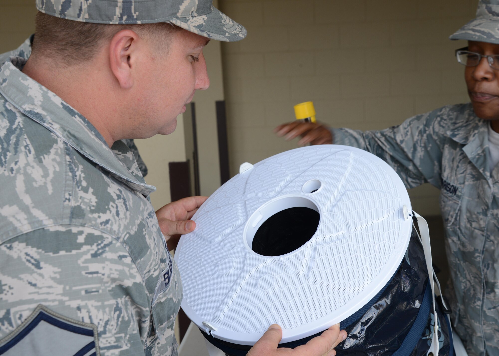 U.S. Air Force Master Sgt. Edward Slaughter, 47th Medical Group first sergeant (left), peers into a mosquito trap during the Healthy Lifestyle Festival at Laughlin Air Force Base, June 13, 2017. Public Health uses these traps to monitor the mosquito population on base, and the potential viruses carried by them. (U.S. Air Force photo/Airman 1st Class Benjamin N. Valmoja)