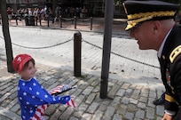 Maj. Gen. Troy D. Kok, commanding general of the U.S. Army Reserve’s 99th Regional Support Command, greets a small child wearing an American flag prior to the start of the Stripes and Stars Festival celebrating the U.S. Army 242nd birthday at Independence Hall in Philadelphia.