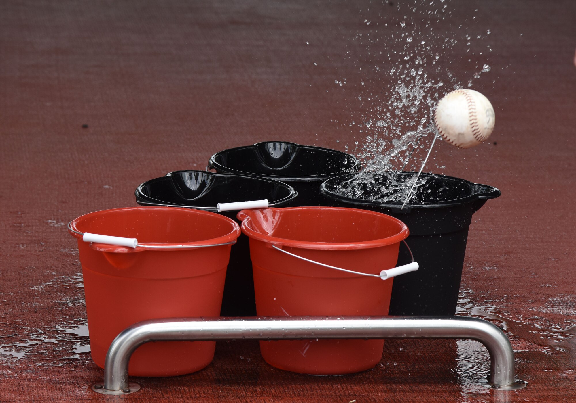 A softball pops out of a water bucket during a bucket pong competition played by Keesler personnel at the Crotwell Track June 12, 2017, on Keesler Air Force Base, Miss. The competition was one of several Wingman Week events focusing on resiliency and teambuilding initiatives across the base. (U.S. Air Force photo by Kemberly Groue)