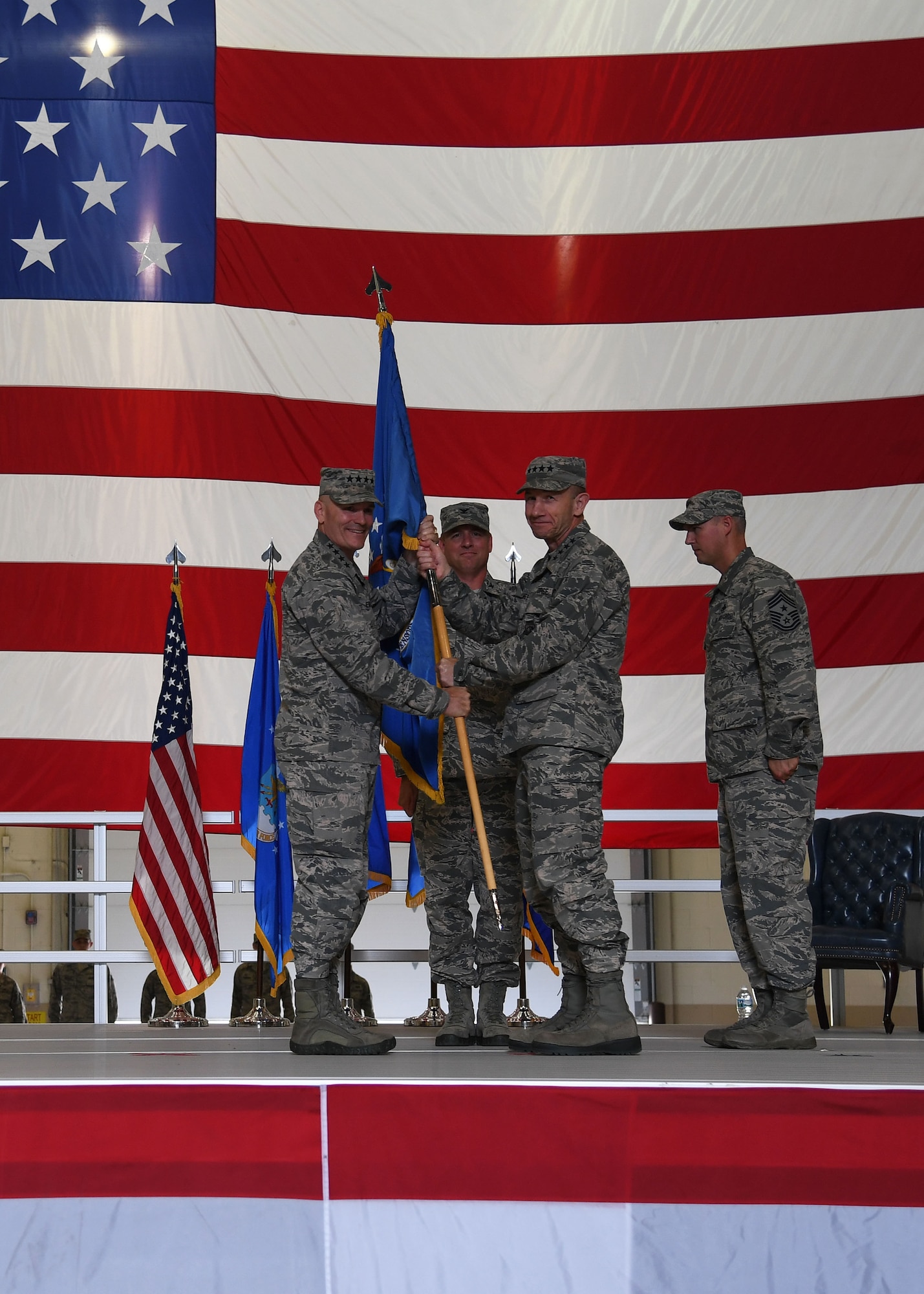 Gen. Mike Holmes, Air Combat commander, right, receives the guidon from Gen. Carlton Everhart, Air Mobility commander, left, during a realignment ceremony at Grand Forks Air Force Base, N.D., June 15, 2017. Passing the guidon symbolizes the change of the 319th Air Base Wing from Air Mobility Command, to Air Combat Command. (U.S. Air Force photo by Airman 1st Class Elora McCutcheon)