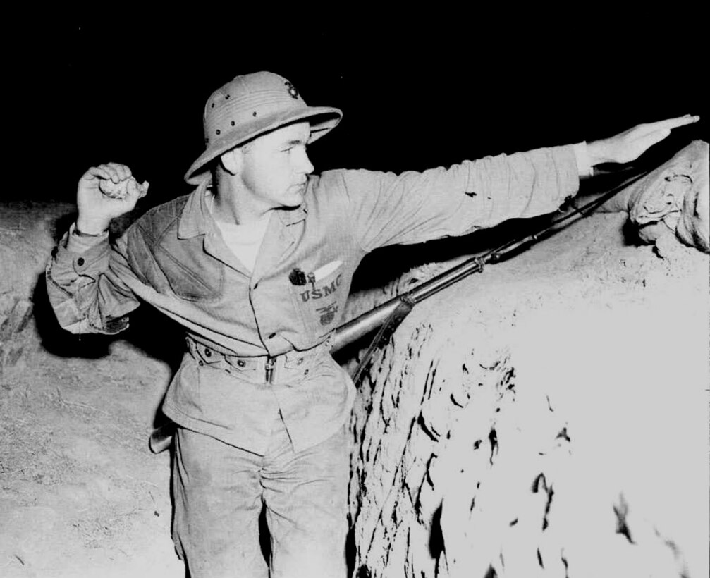 Marine private stands ready to throw a practice hand grenade from a trench at this Marine Corps Rifle Range where he is undergoing intensive recruit training. Camp Matthews, November 1945.