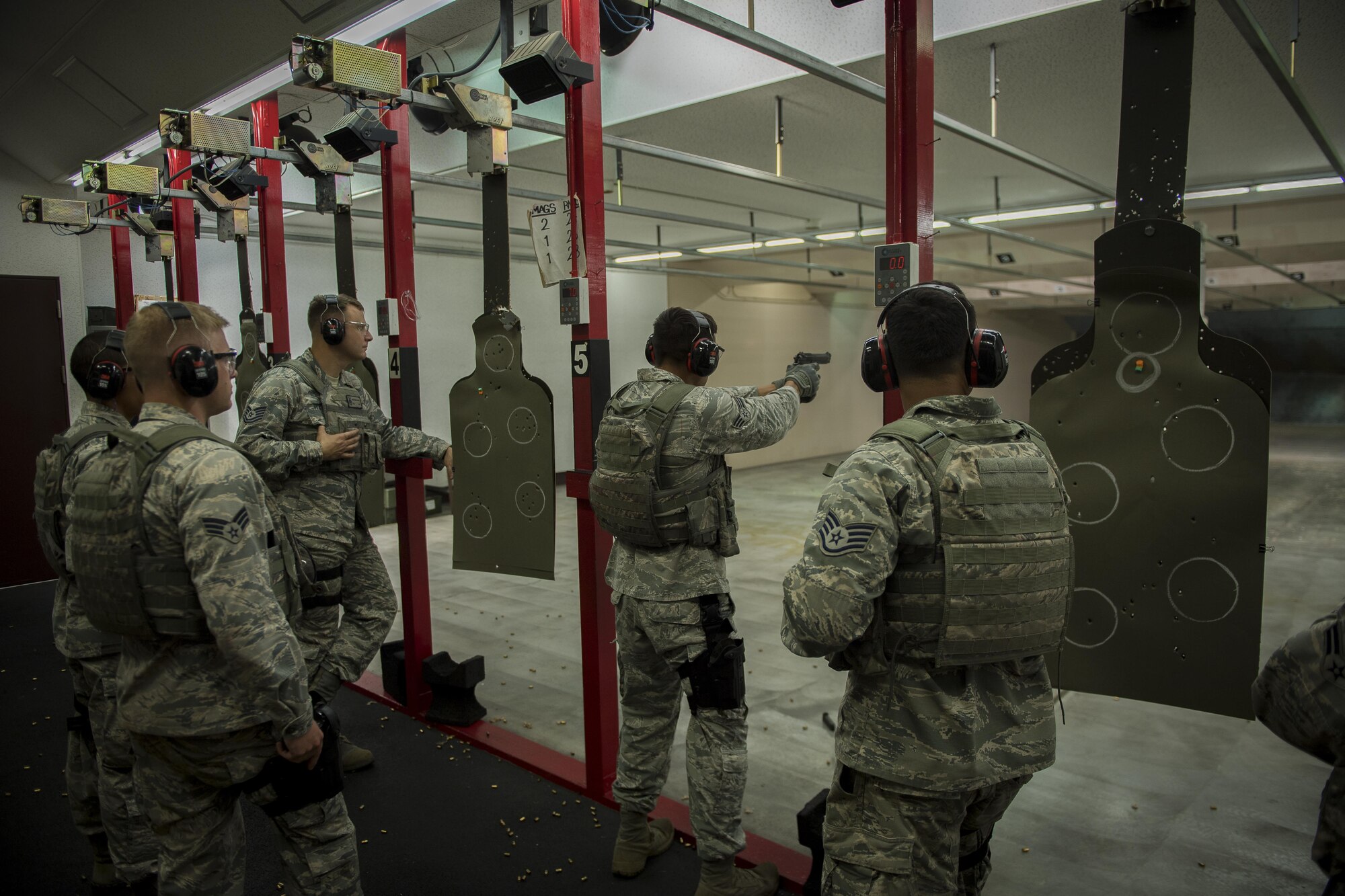 The 374th Security Forces Squadron 2017 Security Forces Advanced Combat Skills Assessment team watch Senior Airman Francisco Daniel Barron, 374 SFS alarm monitor, fire an M9 pistol, June 1, 2017, at Yokota Air Base, Japan. The 374 SFS team regularly practiced firing various weapons including the: M4 carbine assault rifle, M9 pistol, M249 light machine gun and the M203 grenade launcher in preparation for the Advanced Combat Skills Assessment competition at Andersen Air Force Base, Guam. (U.S. Air Force photo by Airman 1st Class Donald Hudson)