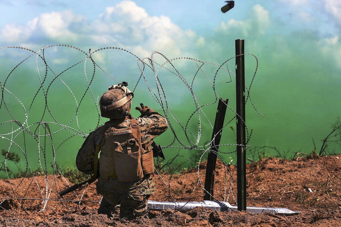 A Marine tosses a smoke grenade during a breach drill at the Adazi military base in Latvia, June 9, 2017, as part of exercise Saber Strike 17. The Marine is assigned to Black Sea Rotational Force 17.1. Marine Corps photo by Cpl. Sean J. Berry