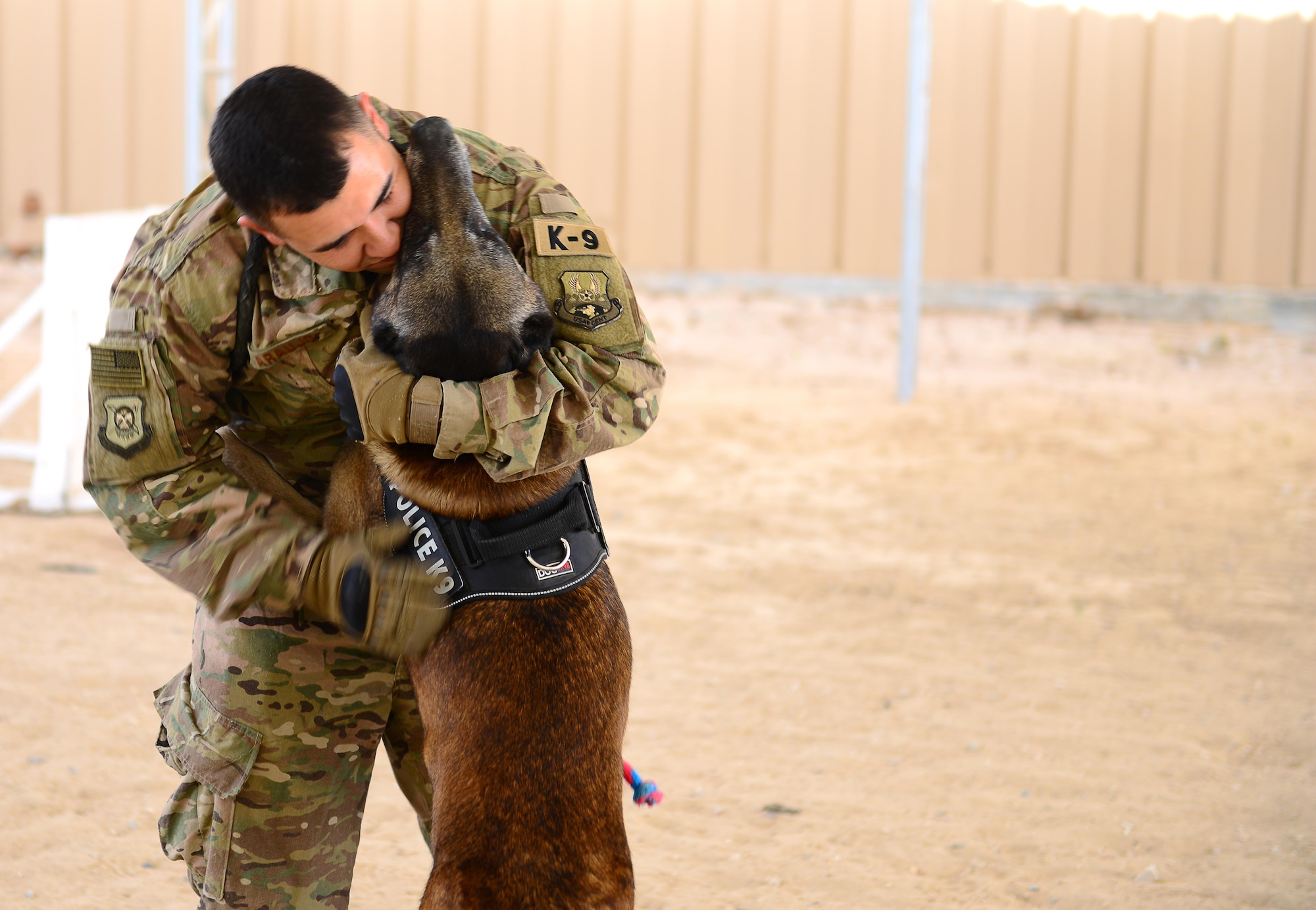 Syrius, a military working dog assigned to the 407th Expeditionary Security Forces Squadron, jumps up and hugs his handler U.S. Air Force Senior Airman Omar Araujo in Southwest Asia on May 23, 2017. Araujo and Syrius have been working together for a close to a year and are deployed in support of Operation Inherent Resolve. (U.S. Air Force photo by Tech Sgt. Andy M. Kin)