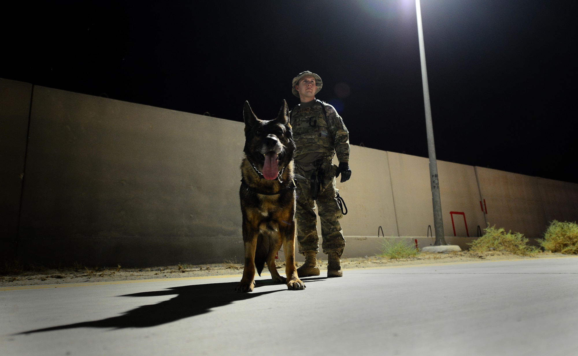 U.S. Air Force Senior Airman Carlton Isaacson, a military working dog handler assigned to the 407th Expeditionary Security Forces Squadron and his partner Egon, patrol the flightline in Southwest Asia on May 23, 2017. Isaacson and Egon have been partners for two years now and are deployed in support of Operation Inherent Resolve. Military working dogs are the first line of defense when it comes to explosive detection and provide security sweeps throughout the installation. (U.S. Air Force photo by Tech Sgt. Andy M. Kin)