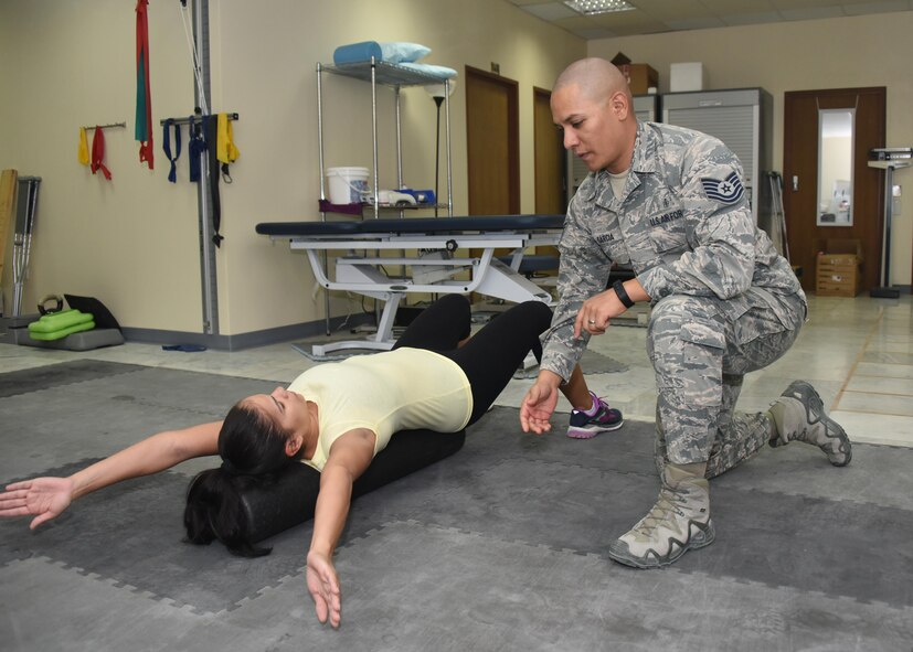 Tech. Sgt. David Garcia (middle), the NCOIC of physical therapy, 386th Expeditionary Medical Group, monitors the form of Staff Sgt. Melanie Hernandez, a patient with the 386th EMDG physical therapy clinic, as she performs squats on a stability ball during a physical therapy session at an undisclosed location in Southwest Asia, June 11, 2017. The physical therapy clinic provides an array of rehabilitative services to promote movement, reduce pain, restore function and prevent disability of injured military personnel. (U.S. Air Force photo/ Tech. Sgt. Jonathan Hehnly)