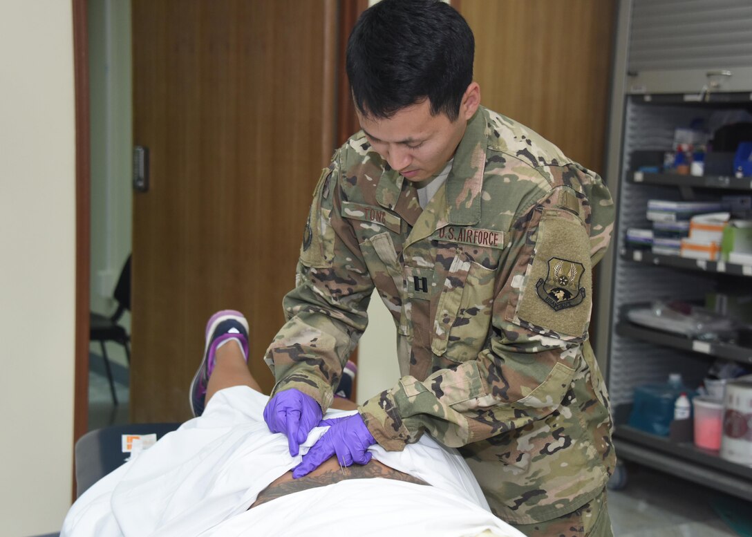 Capt. Grant Tong, the 386th Expeditionary Medical Group physical therapy element chief, conducts dry needling treatment on a patient during a physical therapy session at an undisclosed location in Southwest Asia, June 11, 2017. The physical therapy clinic provides an array of rehabilitative services to promote movement, reduce pain, restore function and prevent disability of injured military personnel. (U.S. Air Force photo/Tech. Sgt. Jonathan Hehnly)