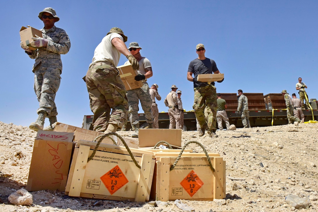 Airmen and Marines unload ordnance and munitions from a trailer during an explosive ordnance disposal operation in Southwest Asia, June 6, 2017. The airmen are assigned to the 407th Air Expeditionary Group. The Marines are assigned to Marine Corps Special Marine Air Ground Task Force. U.S. troops and Italian air force members disposed of more than 5,000 pieces of expired 30 mm rounds and aircraft decoy flares. Air Force photo by Senior Airman Ramon A. Adelan