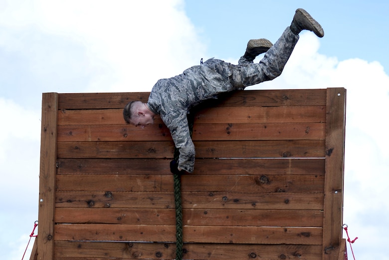 Capt. Kyle Buss, the 36th Security Forces Squadron operations officer, climbs over a wall during the second annual Security Forces Advanced Combat Skills Assessment June 6, 2017, at Andersen Air Force Base, Guam. The mental and physical challenge portion tested basic combat skills and knowledge of competitors at different stations along an obstacle course through the jungle. (U.S. Air Force photo/Airman 1st Class Gerald R. Willis)