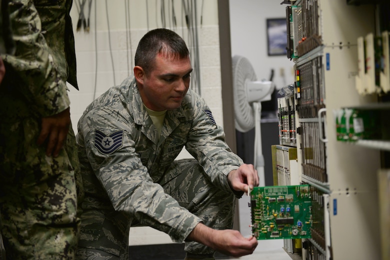 Tech. Sgt. Jonathan Brown, 364th Training Squadron Digital Voice Switching course student inspects a circuit panel on the DMS-100 at Sheppard Air Force Base, Texas. This course provides an introduction to major areas of digital switches for identification of telephone exchange switch equipment. (U.S. Air Force photo by Liz H. Colunga/Released)
