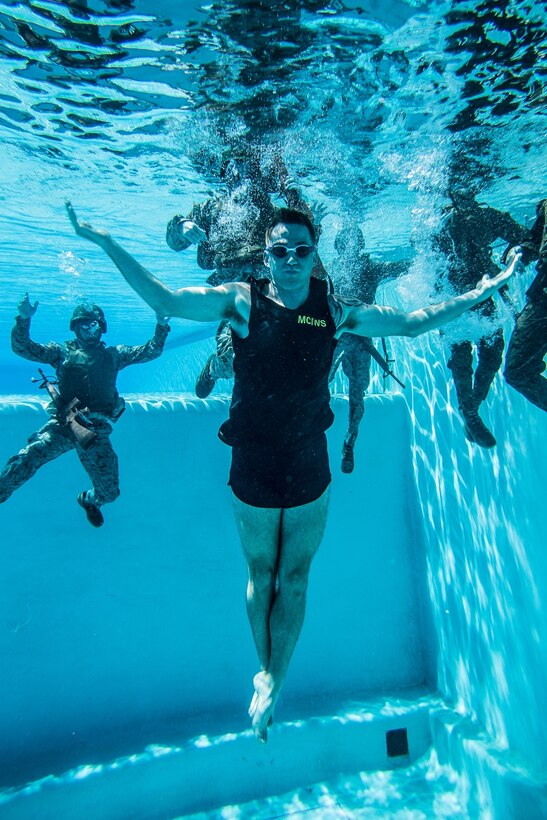 U.S. Marine Cpl. Daniel Ramech, a Marine Corps Instructor of Water Survival with Headquarters Regiment, 1st Marine Logistics Group, observes a water survival advanced course on Camp Pendleton, Calif., June 14, 2017. MCIWS teaches Marines how to improve their abilities in surviving and saving others in water. 1st MLG is home to multiple military occupations that work together to provide support to each element of the 1st Marine Expeditionary Force through logistics beyond the capabilities of the supported units. (U.S. Marine Corps photo by Sgt. Rodion Zabolotiny)