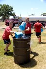 Col. Scott Bell and Capt. Thurmond Jackson, both from Munitions Sustainment Division Team 1, take part in a bucket brigade competition where teams of four fill up 55-gallon drums with water in the shortest possible amount of time. Teams of Airmen from across the base took part in an annual fire muster, which was held at Centennial Park on Hill Air Force Base, June 14, 2017. (Todd Cromar/U.S. Air Force)
