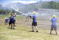 Team ‘F-16 SPO’ faced off against team ‘Diamonds and Pearl’ during a ‘make or break’ competition where each team must roll out fire hoses, connect a nozzle and use the hose to push a hanging bucket to their opponents side, and then break down and roll up their hose. Teams of Airmen from across the base took part in an annual fire muster, which was held at Centennial Park on Hill Air Force Base, June 14, 2017. (Todd Cromar/U.S. Air Force)