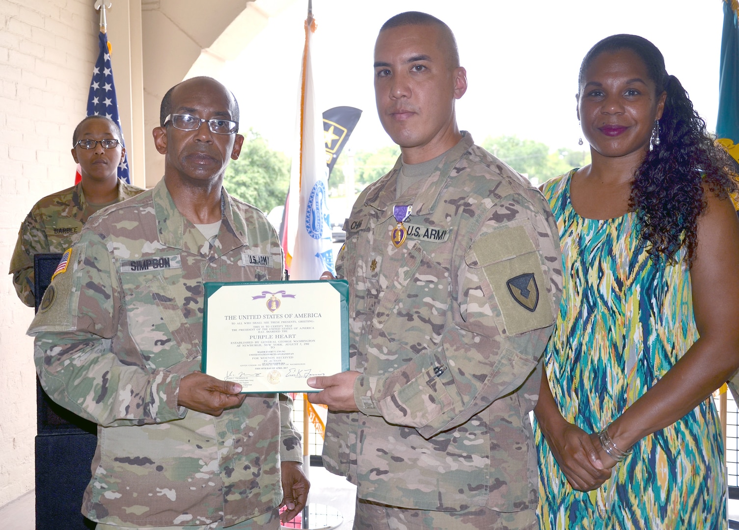 Maj. Gen. James Simpson presents the Purple Heart to Maj. Evan Chung June 9 at Joint Base San Antonio-Fort Sam Houston, Texas. Simpson is the Army Contracting Command commanding general, and Chung is a contracting officer assigned to Field Directorate Office-Fort Sam Houston. Also pictured is Chung’s wife, Nickola.