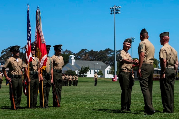 U.S. Marine Col. Phillip N. Frietze (left) and Sgt. Major Carlos A. Ruiz (right) shake hands after Frietze receives his award at the 1st Marine Logistics Group Headquarters Regiment Change of Command on Camp Pendleton, Calif., June 15, 2017. The ceremony included marching of the colors, passing of the regimental colors, presenting Frietze his award and closing remarks from the oncoming and off going personnel as well as the 1st MLG Commanding General, Brig. Gen. David A. Ottignon. (U.S. Marine Corps photo by Lance Cpl. Joseph Sorci)