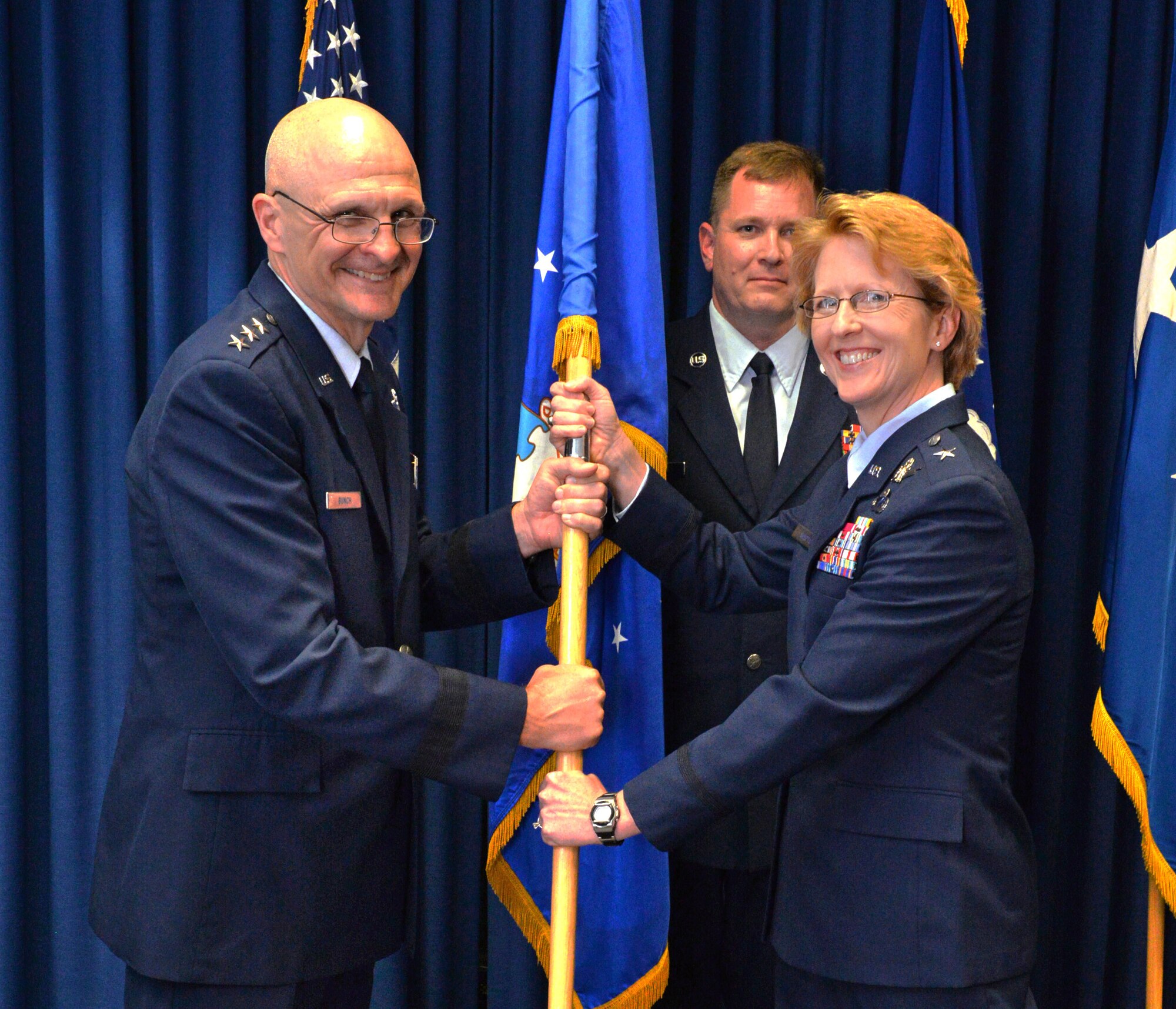 Lt. Gen. Arnold Bunch, Military Deputy, Office of the Assistant Secretary of the Air Force (Acquisition) (L), passes the guidon to Brig. Gen. Donna Shipton (R). Shipton is the new Program Executive Officer for the Tanker Directorate within the Air Force Life Cycle Management Center. In this role she is responsible for the planning and execution of all life cycle activities for the Air Force Tanker fleet. (U.S. Air Force photo / Al Bright) 