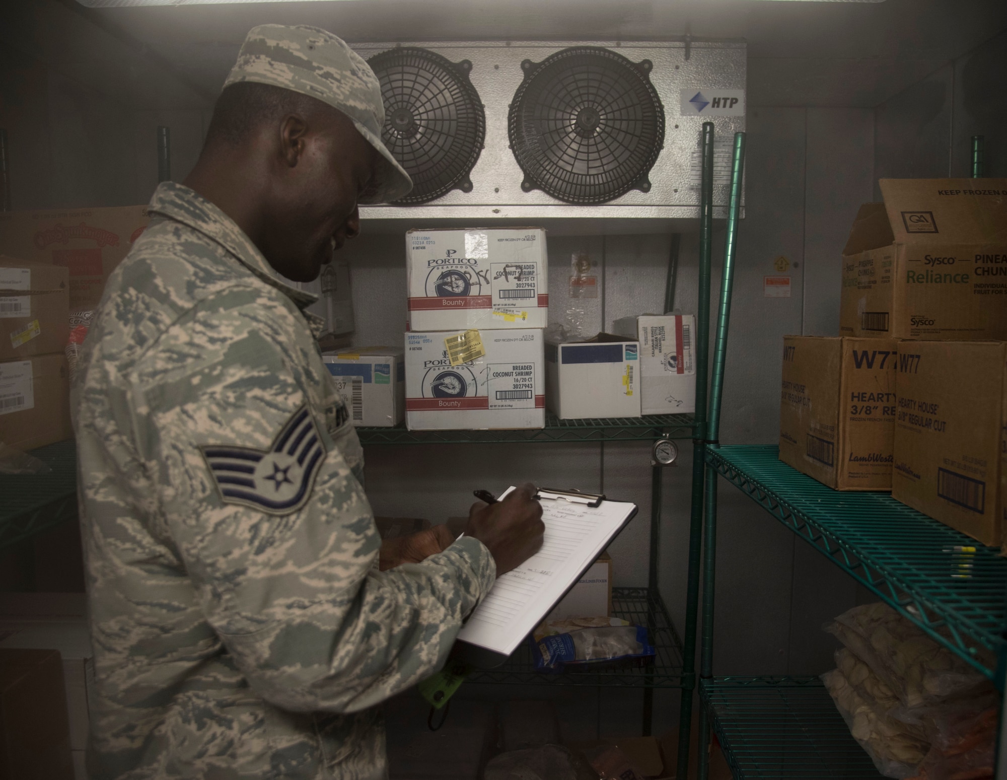 U.S. Air Force Staff Sgt. Cornelius Bransah, the NCO in charge of food safety and sanitation assigned to the 6th Aerospace Medical Squadron, writes down notes after inspecting a walk-in freezer at MacDill Air Force Base, Fla., June 13, 2017. Bransah checks dates, as well as the temperature of the freezer to ensure proper food safety. (U.S. Air Force photo by Airman 1st Class Adam R. Shanks)