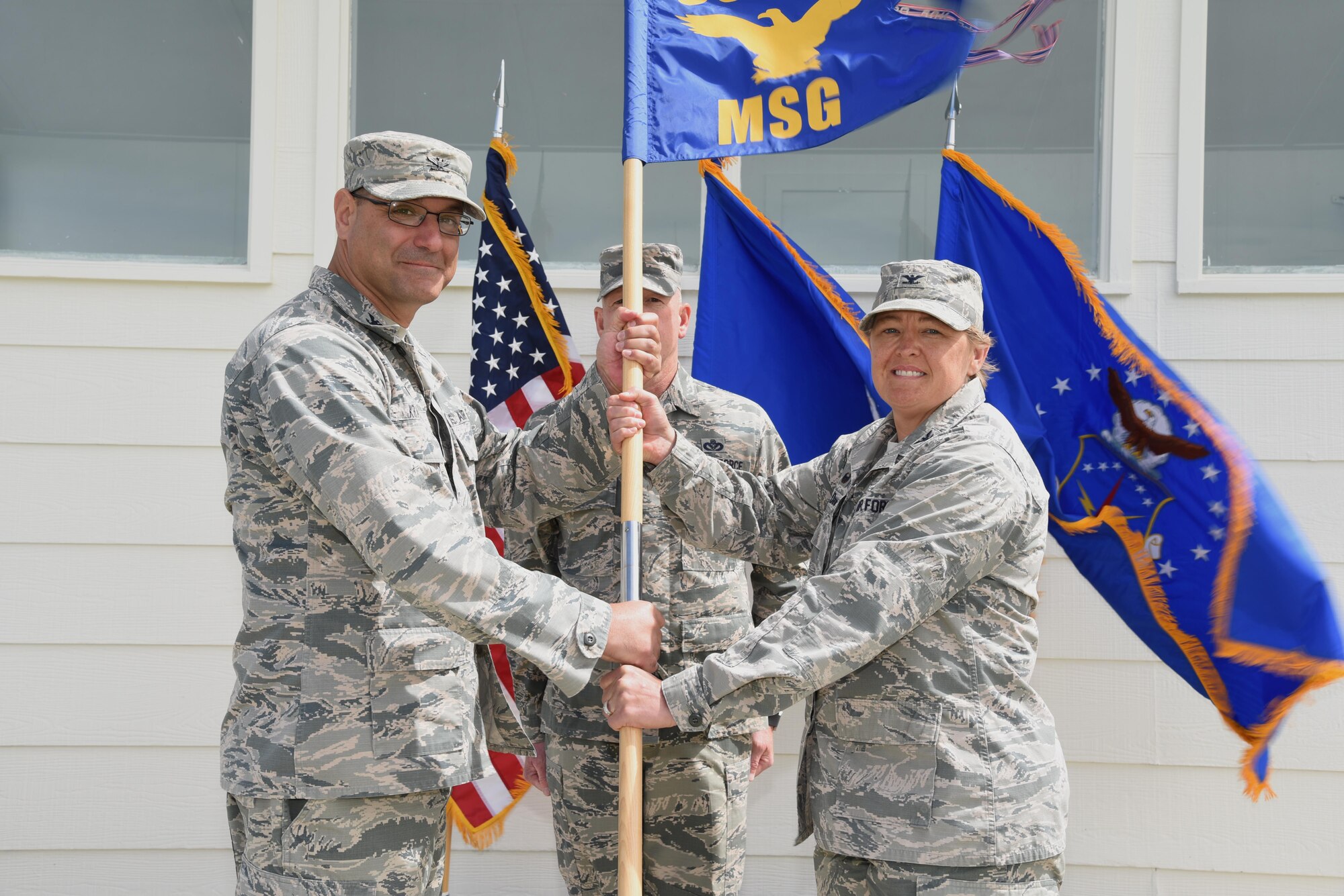 Colonel Stephen Kravitsky, 90th Missile Wing commander, passes the guidon to Col. Tricia Van Den Top, 90th Mission Support Group commander, during the 90th MSG Change of Command ceremony June 16, 2017, on the Argonne Parade Field at F.E. Warren Air Force Base, Wyo. The ceremony signified the transition of command from Col. Frank Verdugo to Van Den Top. (U.S. Air Force photo by Glenn S. Robertson)