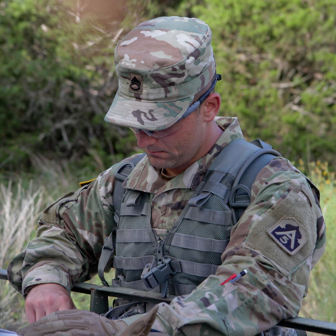 Staff Sgt. Jody McIlroy, a signal intelligence analyst with U.S. Army North at Joint Base San Antonio-Fort Sam Houston, plots his route during the day land navigation event of the Best Warrior Competition June 13 at JBSA-Camp Bullis, 