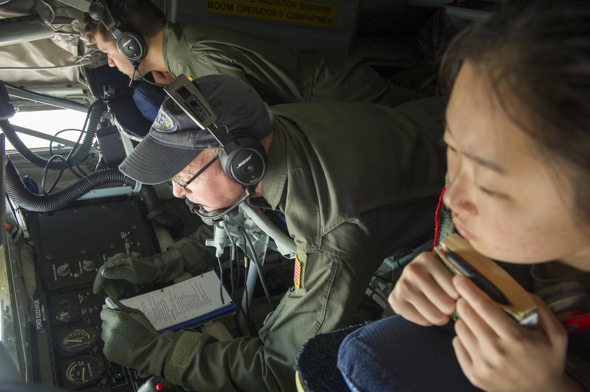 Two cadets from the U.S. Air Force Academy observe Senior Master Sgt. Jim Martin, 314th Air Refueling Squadron boom operator, as he prepares for a refueling trainer mission June 9, 2017. Cadets were given an incentive flight to learn more about the operational Air Force as part of their Ops Air Force tour. (U.S. Air Force photo by Senior Airman Tara R. Abrahams)