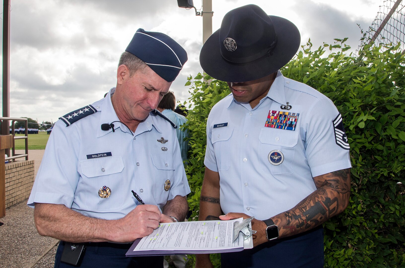 Air Force Chief of Staff Gen. David Goldfein, signs oath of enlistment paperwork for Senior Master Sgt. Steven Beasley, 737th Training Group superintendent of standardization and evaluation, prior to the start of basic military training graduation June 16, 2017, at Joint Base San Antonio-Lackland. Goldfein toured various JBSA-Lackland facilities and met many 37th Training Wing Airmen during his two-day visit. Beasley joined BMT Airmen in reciting the oath as Goldfein administered during the graduation. (U.S. Air Force photo by Johnny Saldivar)
