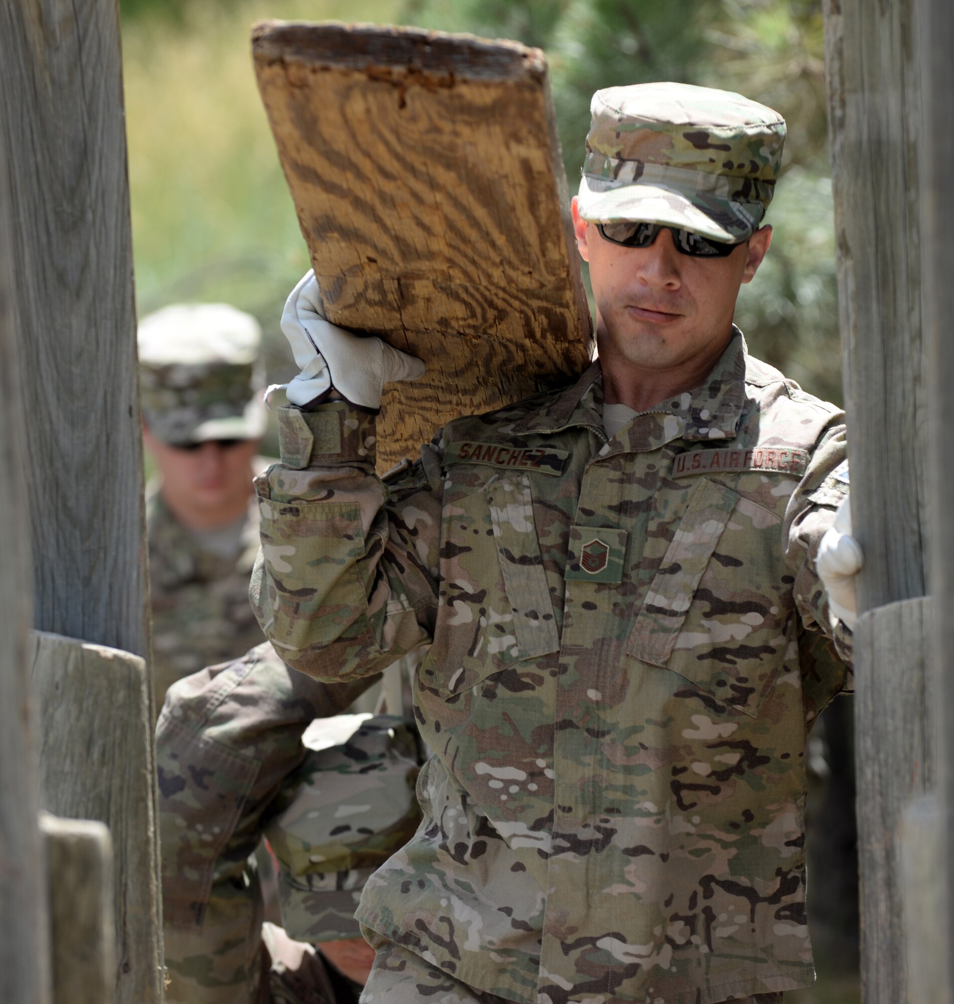 Master Sgt. Carlos Sanchez, an explosive ordnance disposal technician assigned to the 28th Civil Engineer Squadron, carries a wood board to construct a makeshift bridge during at the Leadership Reaction Course at Camp Rapid, Rapid City, South Dakota, June 14, 2017. The LRC training is designed to build teamwork and leadership skills through completing various obstacles. (U.S. Air Force photo by Airman 1st Class Thomas I. Karol)