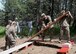 Airmen from the 28th Civil Engineer Squadron work together to complete an obstacle course during the Leadership Reaction Course at Camp Rapid, Rapid City, South Dakota, June 14, 2017. The LRC is designed to build teamwork and leadership skills by completing various obstacles. (U.S. Air Force photo by Airman 1st Class Thomas I. Karol)