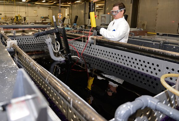 Sebastian Harrelson, an electroplater in the 309th Commodities Maintenance Group, prepares to submerge the nose gear of an F-16 at Hill Air Force Base, Utah. The organization is overhauling an increasing number of landing gear components with a more eco-friendly coating because of a new process developed by Utah-based ES3 under the Air Force SBIR/STTR Program. The coating - made possible by the new application process - has been shown to provide better protection for components and is expected to yield significant savings over the environmental cleanup needed for traditional coatings. (U.S. Air Force Photo/Alex R. Lloyd)