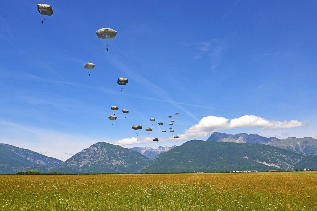Army paratroopers descend over the Juliet drop zone in Pordenone, Italy, June 8, 2017, after jumping from an Air Force C-130 Hercules. Army photo by Davide Dalla Massara