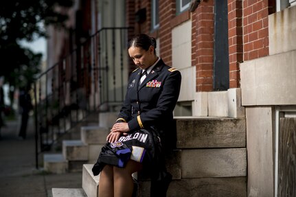 Chief Warrant Officer 2 Jennifer Pace holds her brother's Baltimore Ravens jersey for a portrait in West Baltimore, Maryland, June 15, where she used to work as a police officer before committing her career full time to the U.S. Army Reserve. Pace is among this year's recipients of the General Douglas MacArthur Leadership Award, which she won as a property book officer while working for the 290th Military Police Brigade, headquartered in Nashville, Tennessee. In her leadership journey and professional growth, Pace overcame the loss of her brother, Danny Gamez, who passed away in 2011. (U.S. Army Reserve photo by Master Sgt. Michel Sauret)