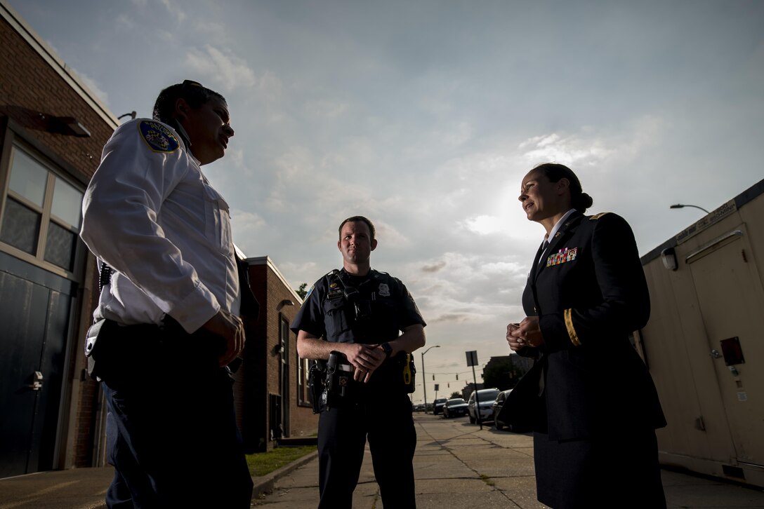 Chief Warrant Officer 2 Jennifer Pace (right) talks with police officers from Baltimore's Western District, June 15, where she used to work as a police officer before committing her career full time to the U.S. Army Reserve. Pace is among this year's recipients of the General Douglas MacArthur Leadership Award, which she won as a property book officer while working for the 290th Military Police Brigade, headquartered in Nashville, Tennessee. In her leadership journey and professional growth, Pace overcame the loss of her brother, Danny Gamez, who passed away in 2011. (U.S. Army Reserve photo by Master Sgt. Michel Sauret)