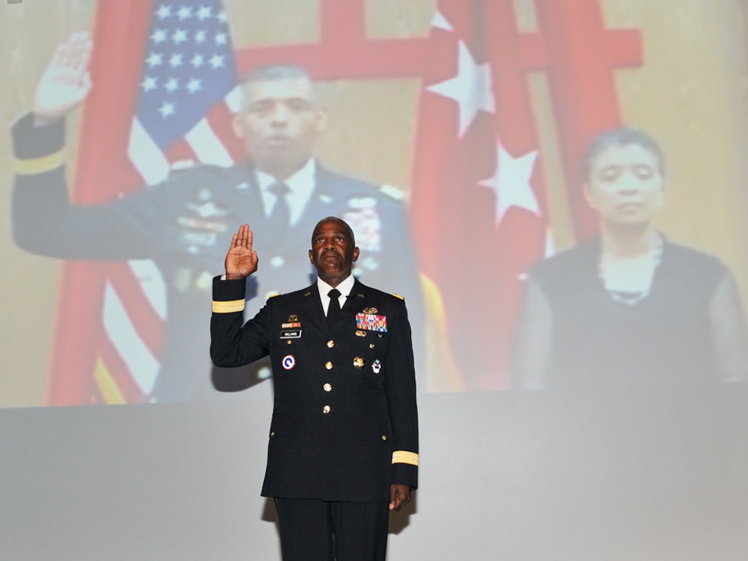 DLA Director Army Lt. Gen. Darrell Williams takes the oath of office, administered by Army Gen. Vincent Brooks (on screen), commander of U.S. Forces Korea, with wife Carol Brooks at right.