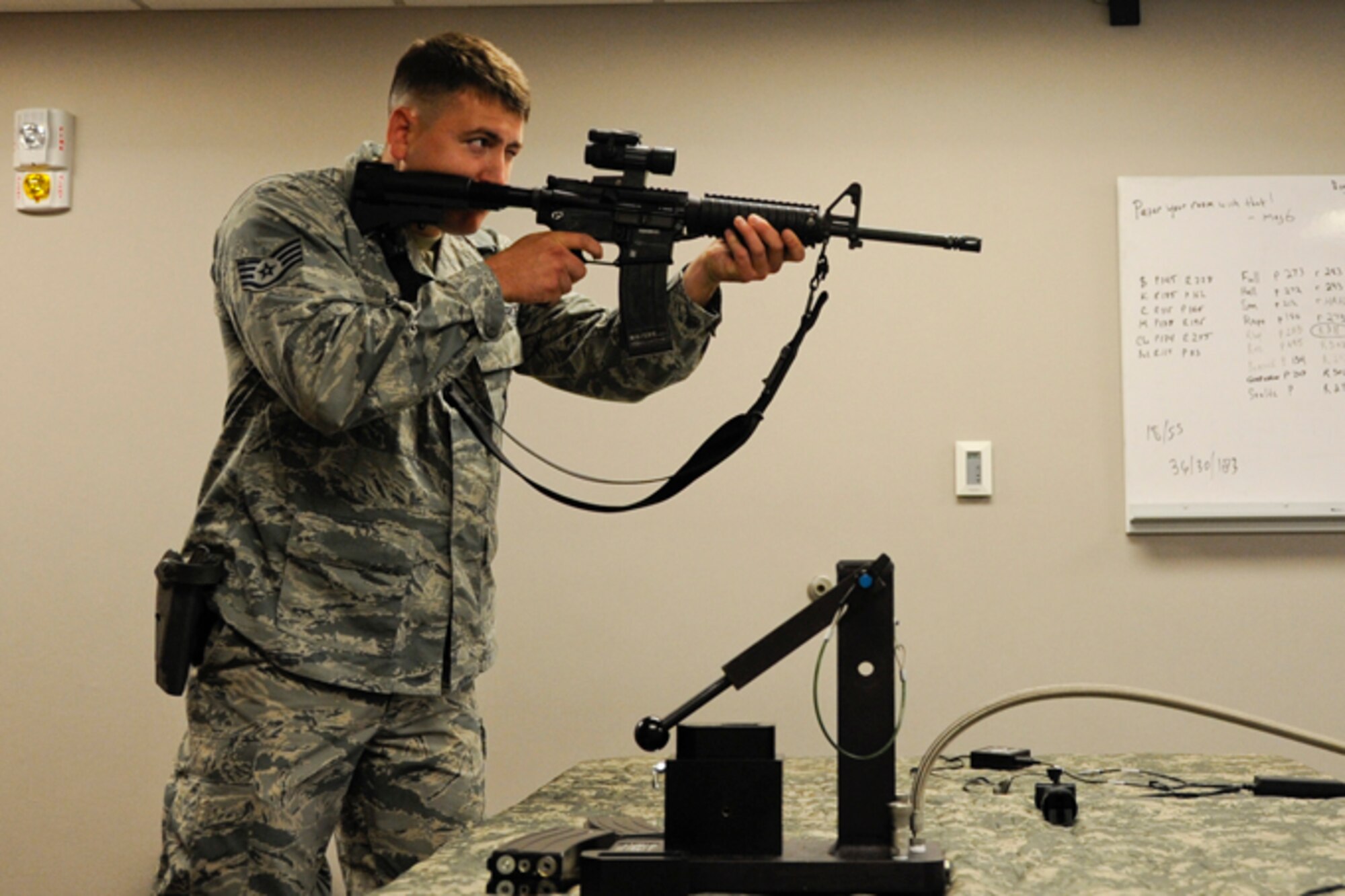 Staff Sgt. Jade Bess, 434th Security Forces Squadron security response team member, takes aim on the firearms training simulator at Grissom Air Reserve Base, Indiana, May 30, 2017. The system allows for real-life training with the weapons used on the job. (U.S. Air Force photo/Senior Airman Cali Wetli)