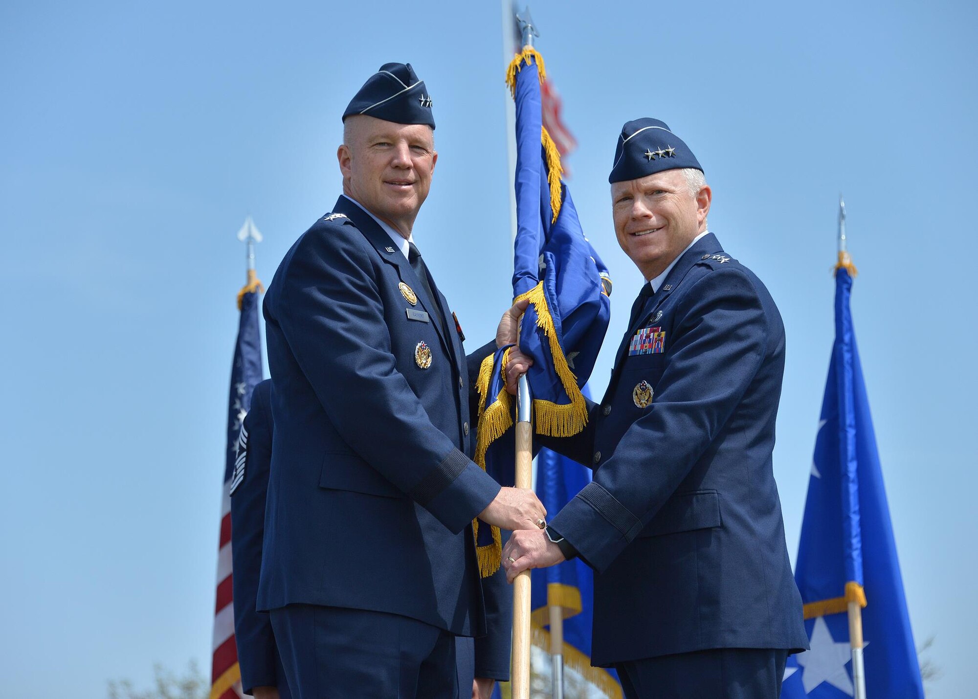 Lt. Gen. John Thompson, incoming SMC commander, accepts the flag of command from Gen. John Raymond, commander of Air Force Space Command, during a change of command ceremony May 22 on the parade grounds of historic Fort MacArthur in San Pedro. (US Air Force photo/Van Ha)