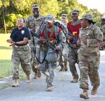 Fellow competitors, sponsor and cadre motivate Staff Sgt. Michael Floore (center) as he nears the finish of a 12-mile foot march carrying a 35-pound ruck as part of the 2017 Army Contracting Command Best Warrior Competition June 8 at Joint Base San Antonio-Camp Bullis. Floore was one of seven Soldiers from throughout the command vying for the best warrior title over five days of competition and right to represent ACC at the Army Materiel Command level in July. The competition included several events aimed at testing the tactical skills of contracting NCOs in the 51-Charlie military occupational specialty. Floore is a contract specialist with the 410th Contracting Support Brigade at JBSA-Fort Sam Houston.