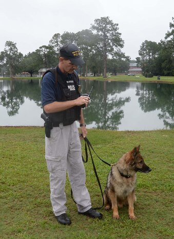 Cpl. James Medders, police officer/dog handler, Marine Corps Police Department, Marine Corps Logistics Base Albany, and his K-9 Military Working Dog search the perimeter of Covella Pond during a “Lost-Child” full-scale exercise on the installation, June 13. The training scenario included reports that a young boy was seen entering the water at the pond. There were roughly 50-60 personnel from the base as well as the city’s mutual partners, who participated in the day-long event.