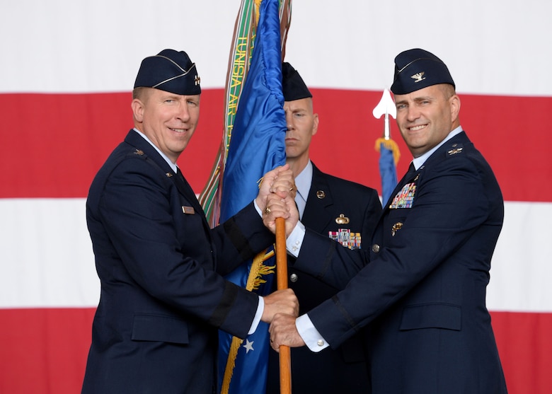 U.S. Air Force Major General Patrick J. Doherty, 19th Air Force commander, passes the guidon to U.S. Air Force Col. Eric Carney, June 16, 2017, at Altus Air Force Base, Oklahoma. U.S. Air Force Col. Todd Hohn relinquished command of the wing to U.S. Air Force Col. Eric Carney, he will lead the base in the mission of forging combat mobility forces and deploying Airmen warriors. (U.S. Air Force Photo by Airman 1st Class Jackson N. Haddon/Released).