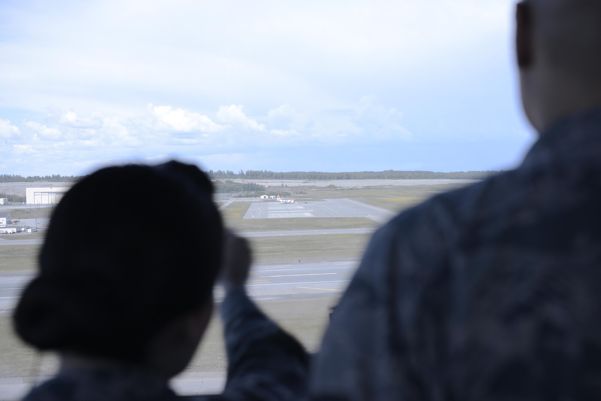 U.S. Air Force Staff Sgt. Amanda Ahsoak, air traffic control journeyman, spots an aircraft in the distance flying over Joint Base Elmendorf-Richardson, Alaska, June 15, 2017. ATC Airmen are responsible for the safety and control of hundreds of military and civilian aircraft every day. 
