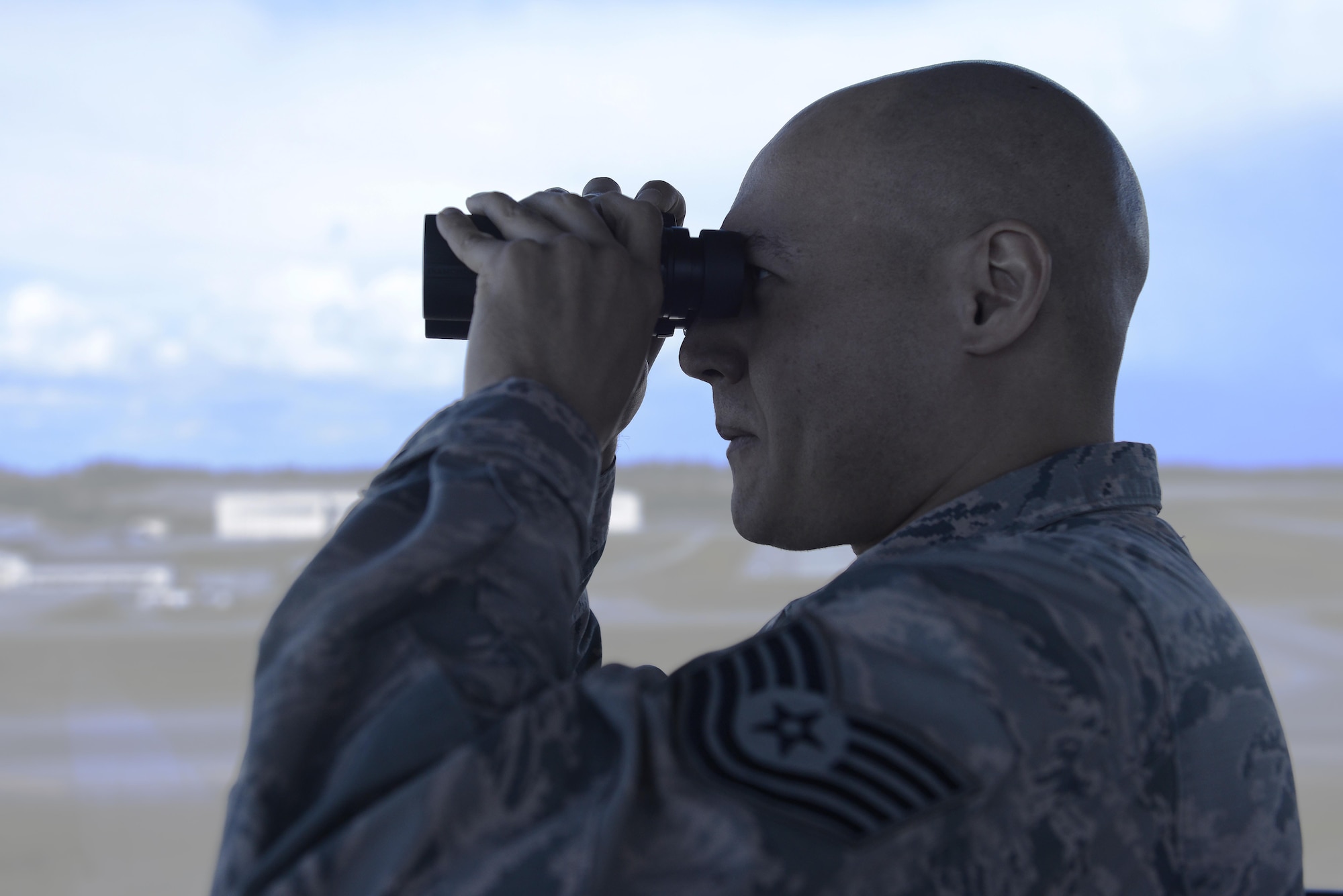 U.S. Air Force Tech. Sgt. Jason McLean, air traffic control tower watch supervisor, looks for an inbound aircraft at Joint Base Elmendorf-Richardson, Alaska, June 15, 2017. ATC Airmen are responsible for the safety and control of hundreds of military and civilian aircraft every day. 